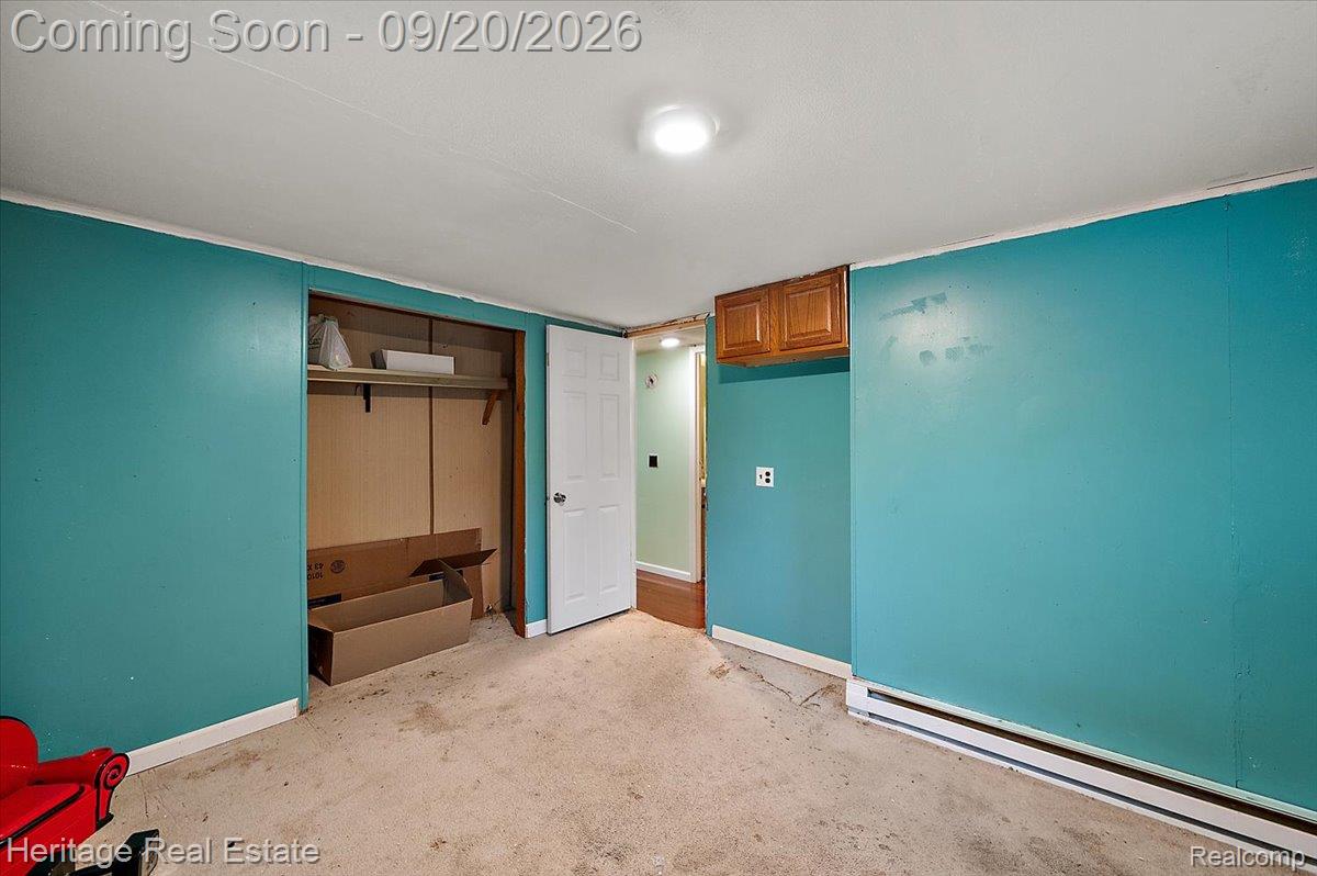 3337 Le Valley Road Columbiaville, MI 48421 - Photo 19 of 57 Recessed ceiling light, built-in wooden cabinetry, white interior door, wall-mounted heating element, and built-in closet with shelving