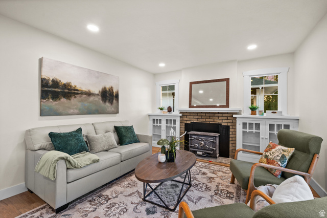 189 West Center Street Midvale, UT 84047 - Photo 7 of 64 Living room featuring a brick fireplace with an ornate wood-burning stove insert, flanked by built-in cabinetry with glass-front doors