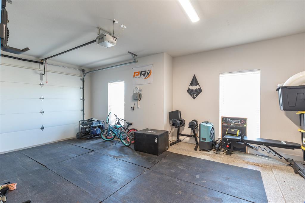 107 Kleingrass Road Abilene, TX 79606 - Photo 28 of 33 Spacious garage featuring a motorized overhead door, two windows, recessed lighting, and a durable epoxy-coated floor