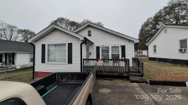 a view of house with a deck and furniture