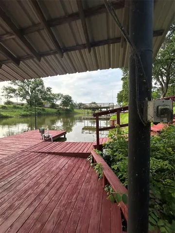 a view of a deck with wooden floor and lake view