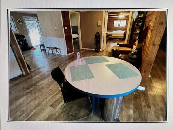 a view of a dining room with furniture wooden floor carpet and a chandelier