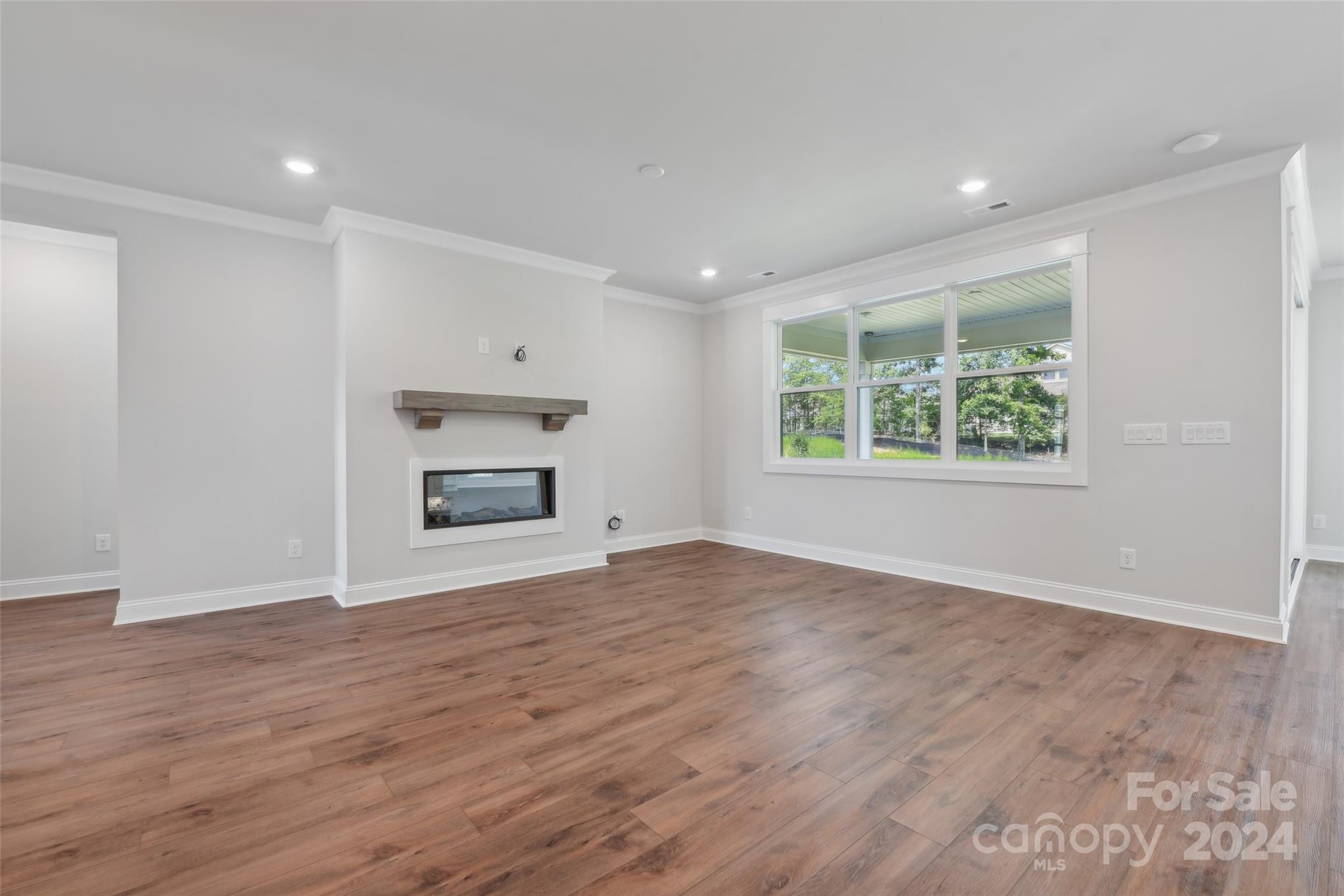 142 Windy Dell Drive Tega Cay, SC 29708 - Photo 13 of 20 an empty room with wooden floor windows and cabinet