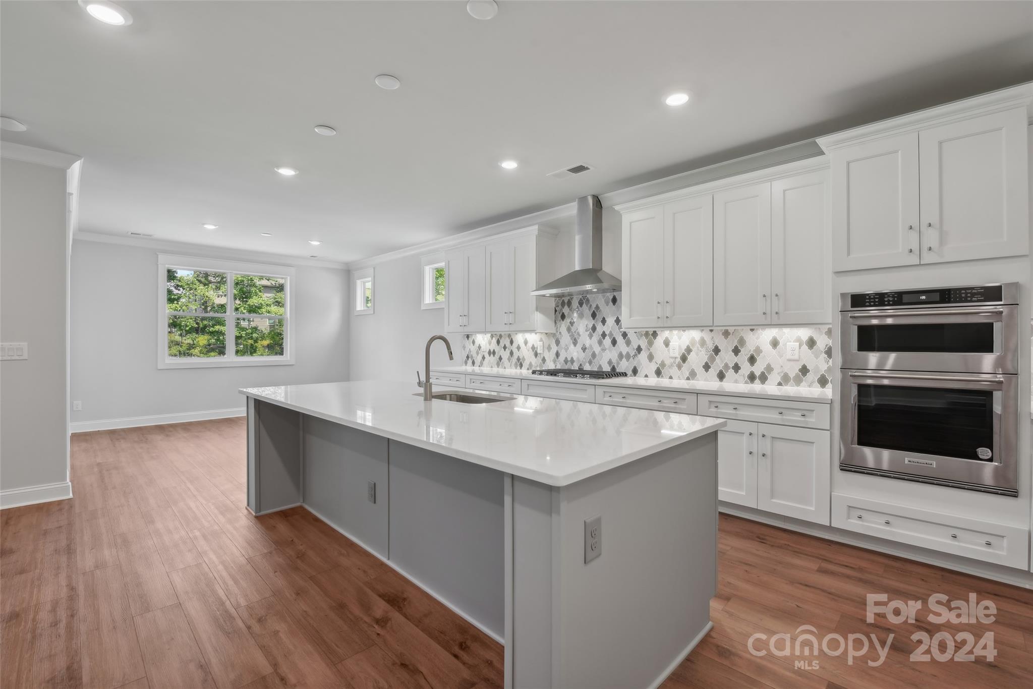 142 Windy Dell Drive Tega Cay, SC 29708 - Photo 8 of 20 a kitchen with kitchen island granite countertop a sink cabinets and wooden floor