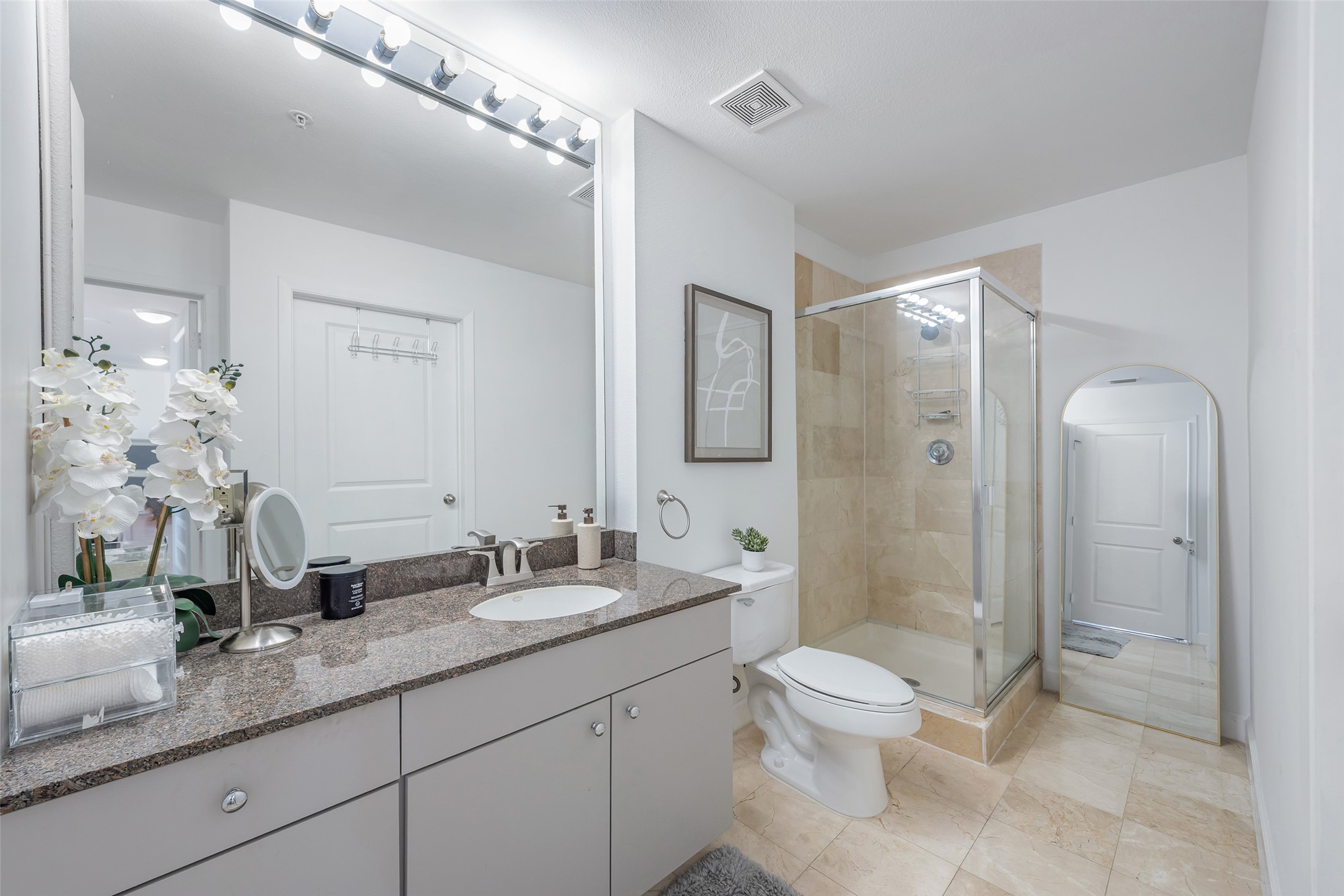 3505 Sage Road, Unit 2210 Houston, TX 77056 - Photo 23 of 40 The second bath is spacious and features a sleek shower, oversized mirror, plenty of light, and abundant storage cabinets for effortless organization.