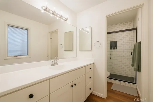 a bathroom with a shower sink and mirror