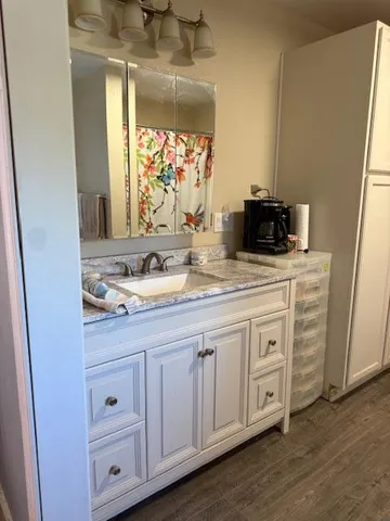 a kitchen with white cabinets and sink