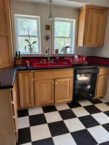 a kitchen with a black white checkered floor and a window