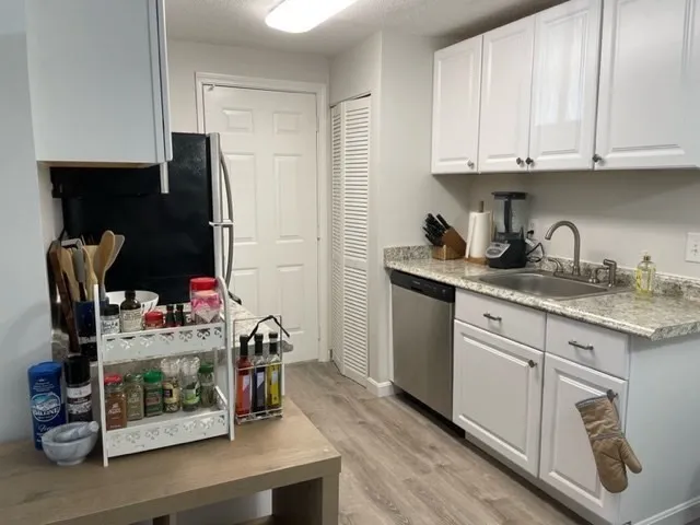 a kitchen with stainless steel appliances granite countertop a refrigerator sink and stove