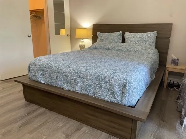 a bedroom with a bed and wooden floor