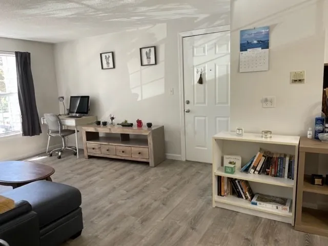 a living room with furniture and a wooden floor