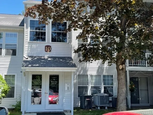 a front view of a house with a tree