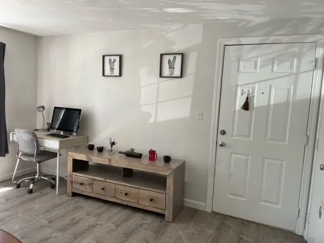 a view of a workspace with furniture and a window