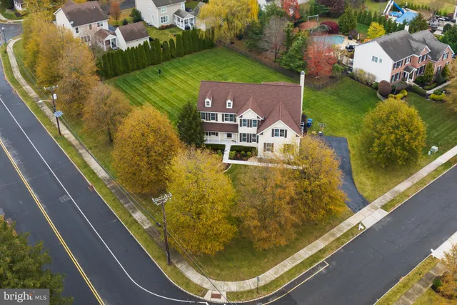 a front view of a house with garden and trees