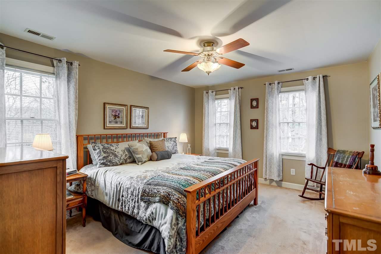 5121 Celbridge Place Raleigh, NC 27613 - Photo 11 of 22 a bedroom with a bed and a chandelier