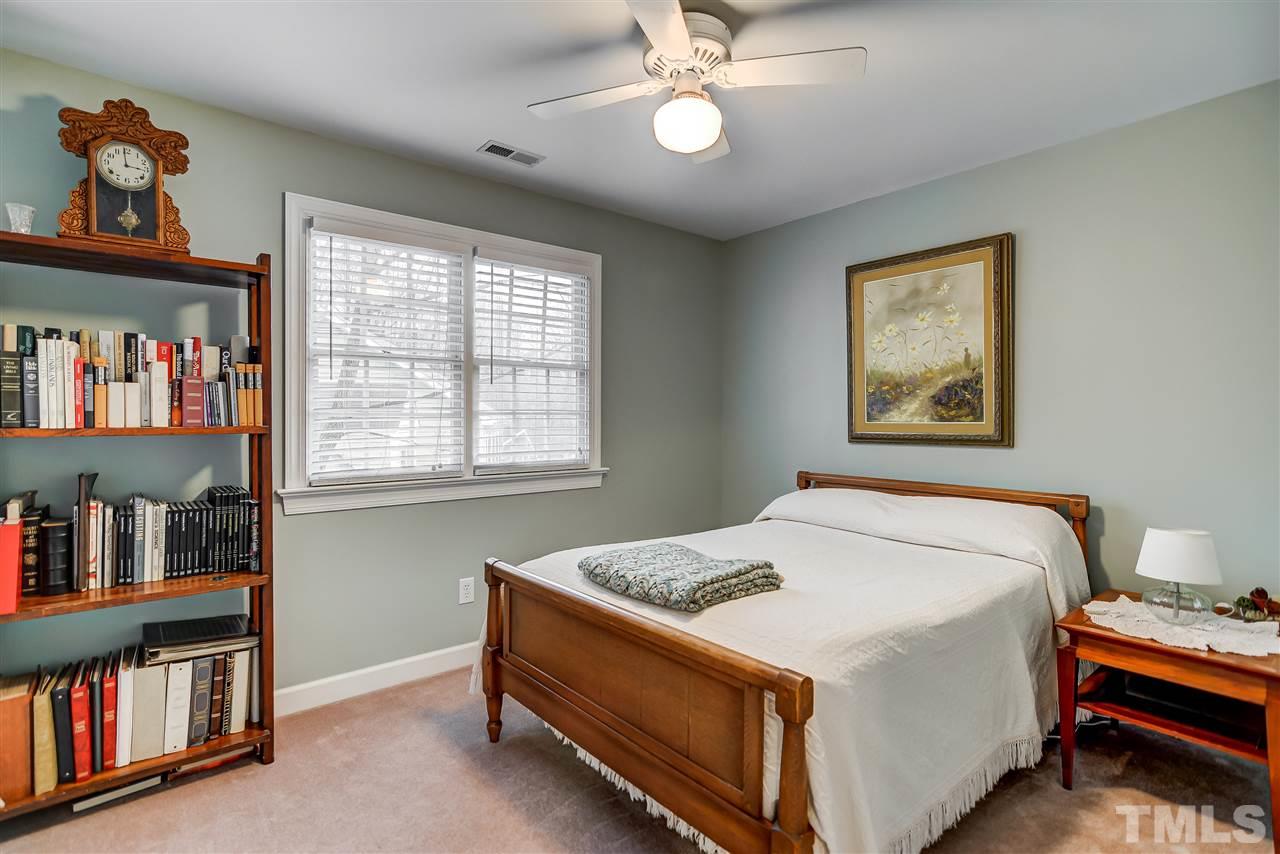 5121 Celbridge Place Raleigh, NC 27613 - Photo 14 of 22 a bed sitting in a bedroom next to a book shelf