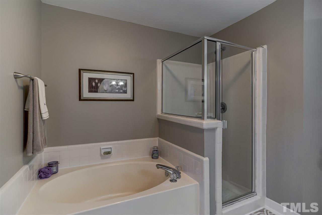 5121 Celbridge Place Raleigh, NC 27613 - Photo 18 of 22 a bathroom with a tub and a shower