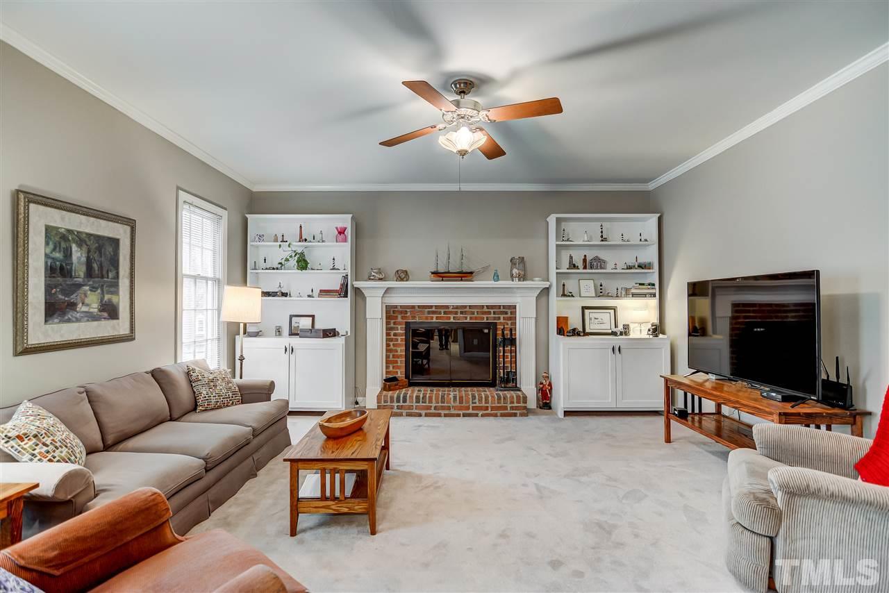 5121 Celbridge Place Raleigh, NC 27613 - Photo 5 of 22 a living room with furniture a flat screen tv and a fireplace