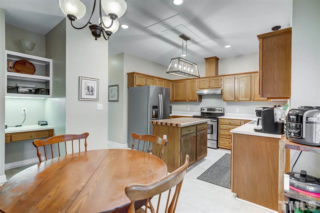 5121 Celbridge Place Raleigh, NC 27613 - Photo 8 of 22 a kitchen with stainless steel appliances a table chairs refrigerator and cabinets