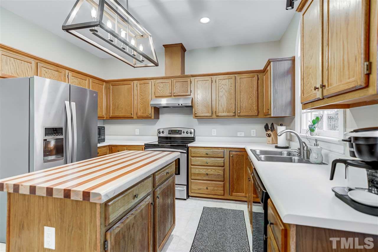 5121 Celbridge Place Raleigh, NC 27613 - Photo 9 of 22 a kitchen with stainless steel appliances granite countertop a sink stove and refrigerator
