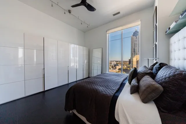 a bed room with a bed a couch and a ceiling fan