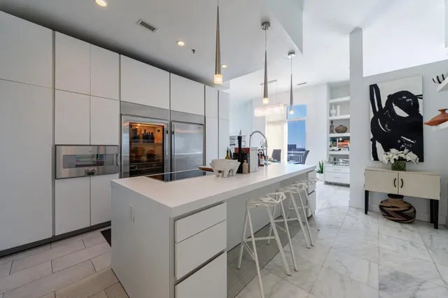 a kitchen with a sink a refrigerator and chairs