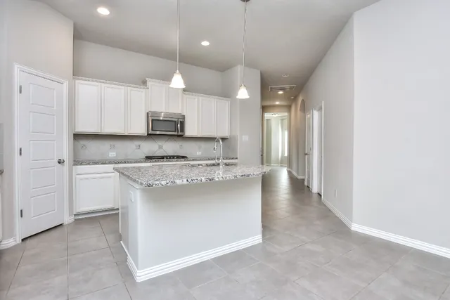 a kitchen with stainless steel appliances granite countertop a stove a sink and a refrigerator