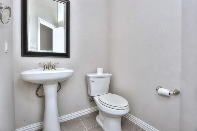 an empty room with wooden floor chandelier fan and windows