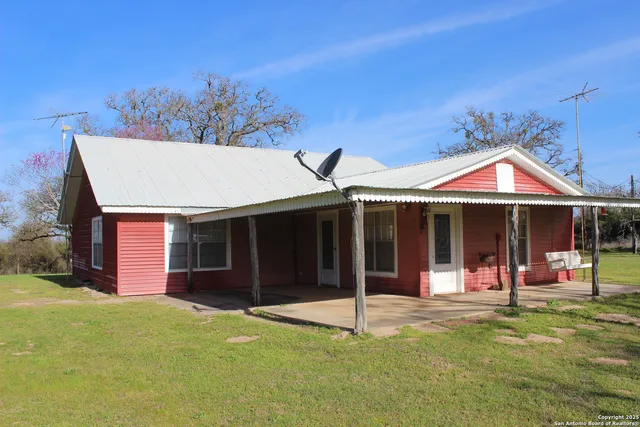 a view of a house with a yard and porch