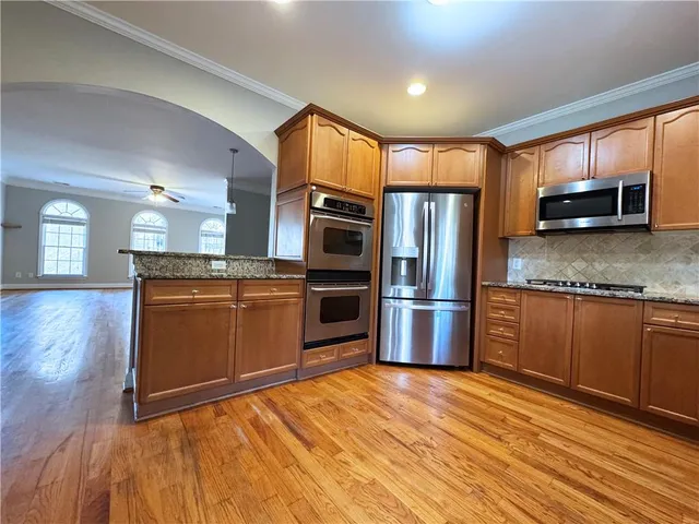a kitchen with stainless steel appliances granite countertop a refrigerator a stove a sink and dishwasher