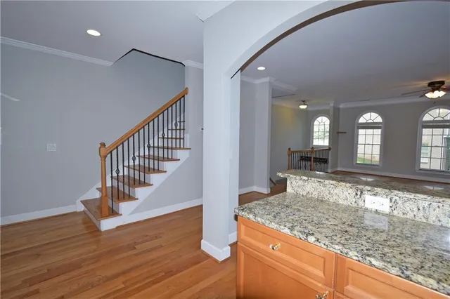 a view of a hallway with wooden floor and staircase