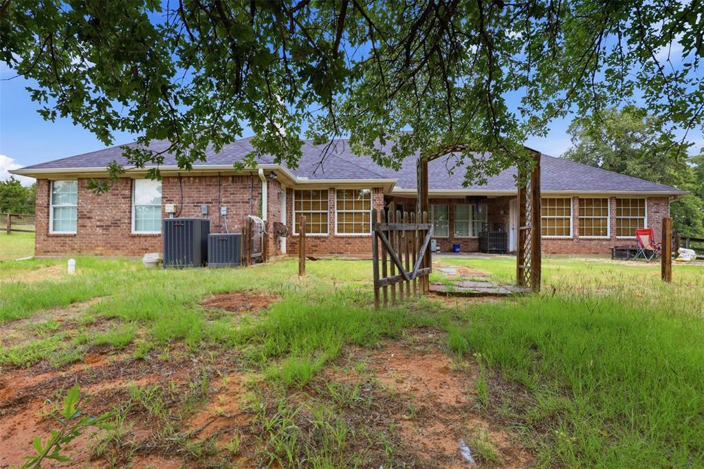 4417 Slayton Road Cleburne, TX 76031 - Photo 8 of 28 Brick exterior with a dark shingle roof and multiple windows