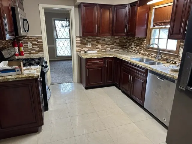 a kitchen with stainless steel appliances granite countertop a stove top oven sink and cabinets