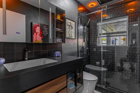 a bathroom with a sink a toilet and shower