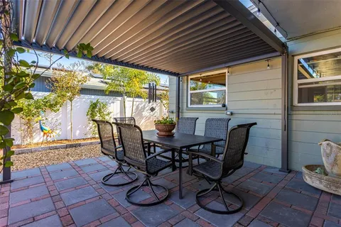 a view of a patio with a table and chairs under an umbrella