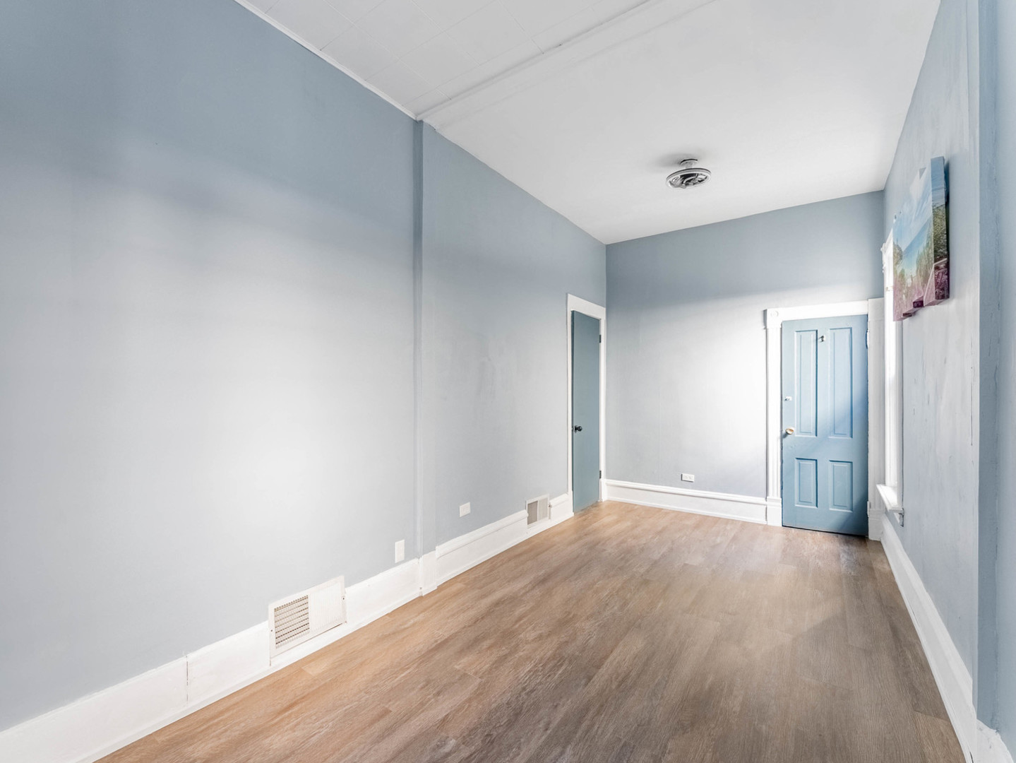 7041 South Throop Street Chicago, IL 60636 - Photo 5 of 36 a view of an empty room with wooden floor