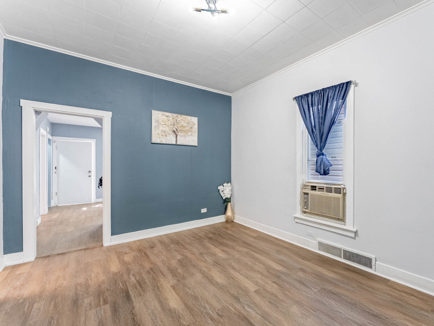 7041 South Throop Street Chicago, IL 60636 - Photo 6 of 36 a view of an empty room with wooden floor and a window