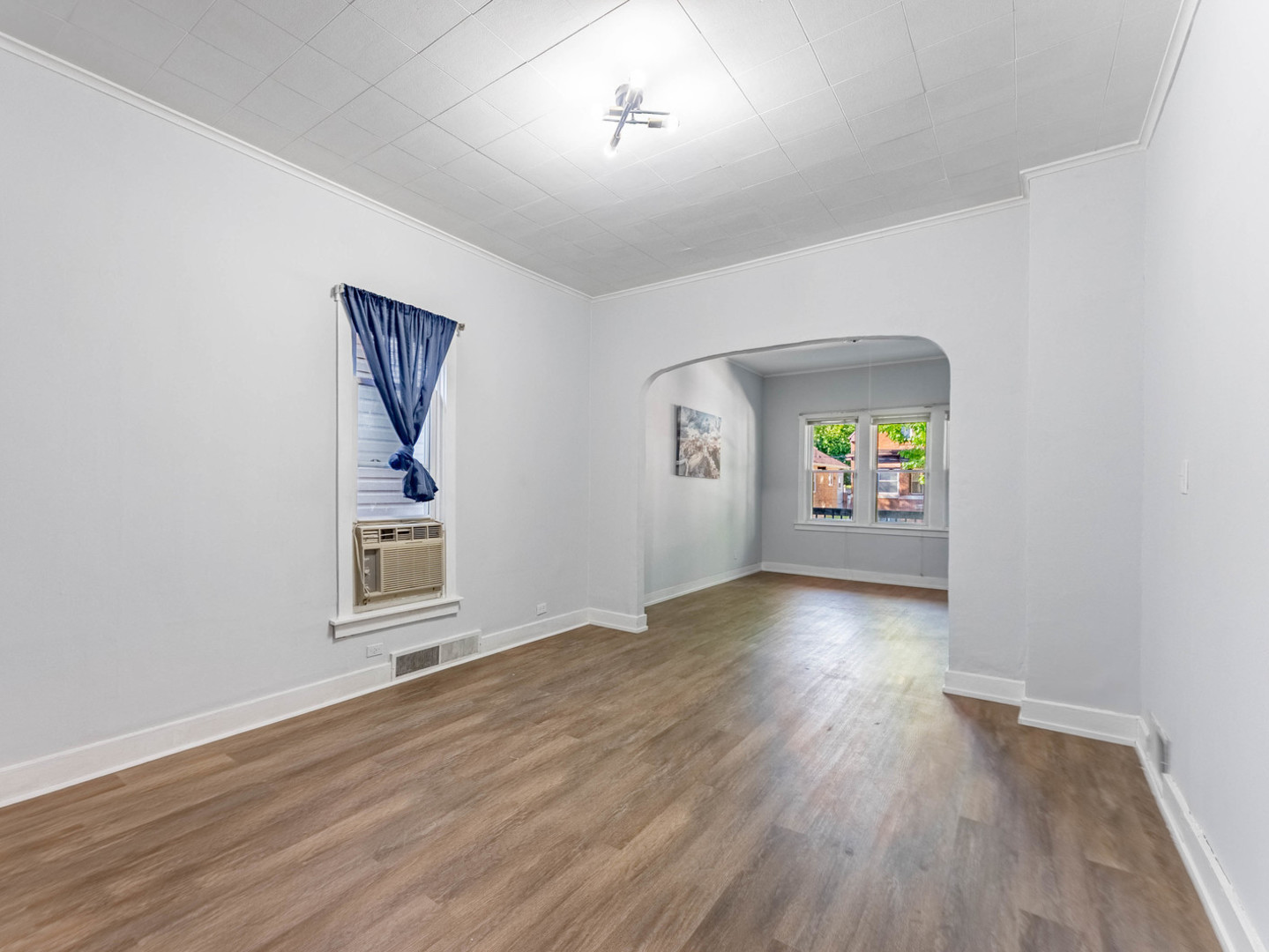 7041 South Throop Street Chicago, IL 60636 - Photo 8 of 36 an empty room with window and wooden floor