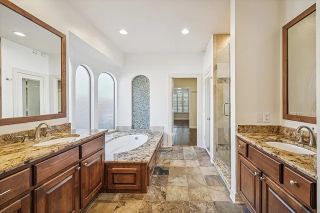 a spacious bathroom with a granite countertop sink a mirror and a shower