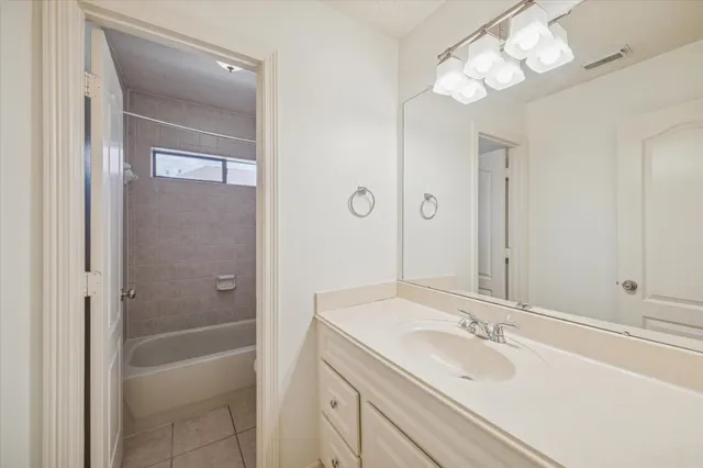 a bathroom with a granite countertop sink a toilet and shower