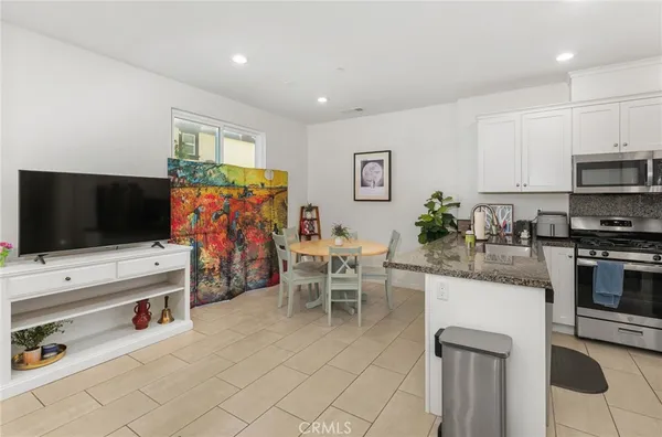 a kitchen with stainless steel appliances kitchen island granite countertop a stove and a sink
