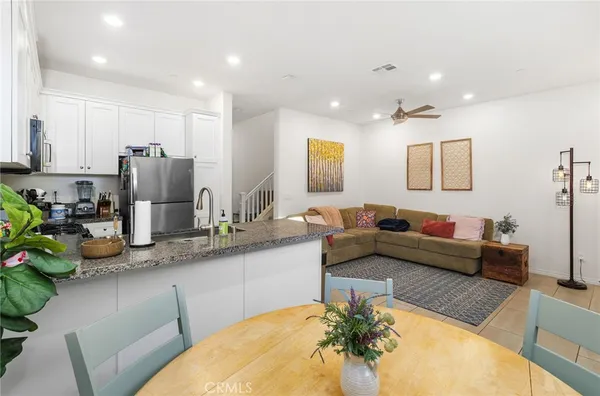 a living room with stainless steel appliances furniture and a chandelier
