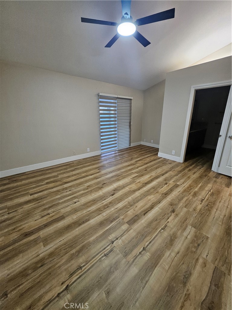 4481 Wyngate Circle Irvine, CA 92604 - Photo 26 of 42 a view of an empty room with wooden floor and a ceiling fan