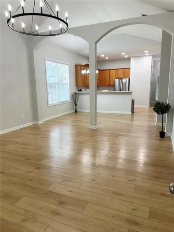 an empty room with wooden floor and outdoor view