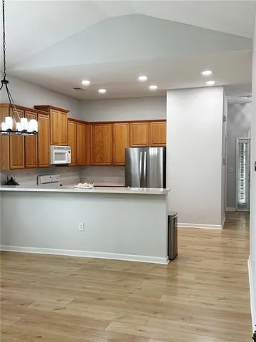 a view of kitchen with stainless steel appliances granite countertop a refrigerator a sink dishwasher and a microwave oven on the wall