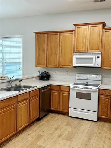 a kitchen with stainless steel appliances granite countertop a stove a sink and a microwave
