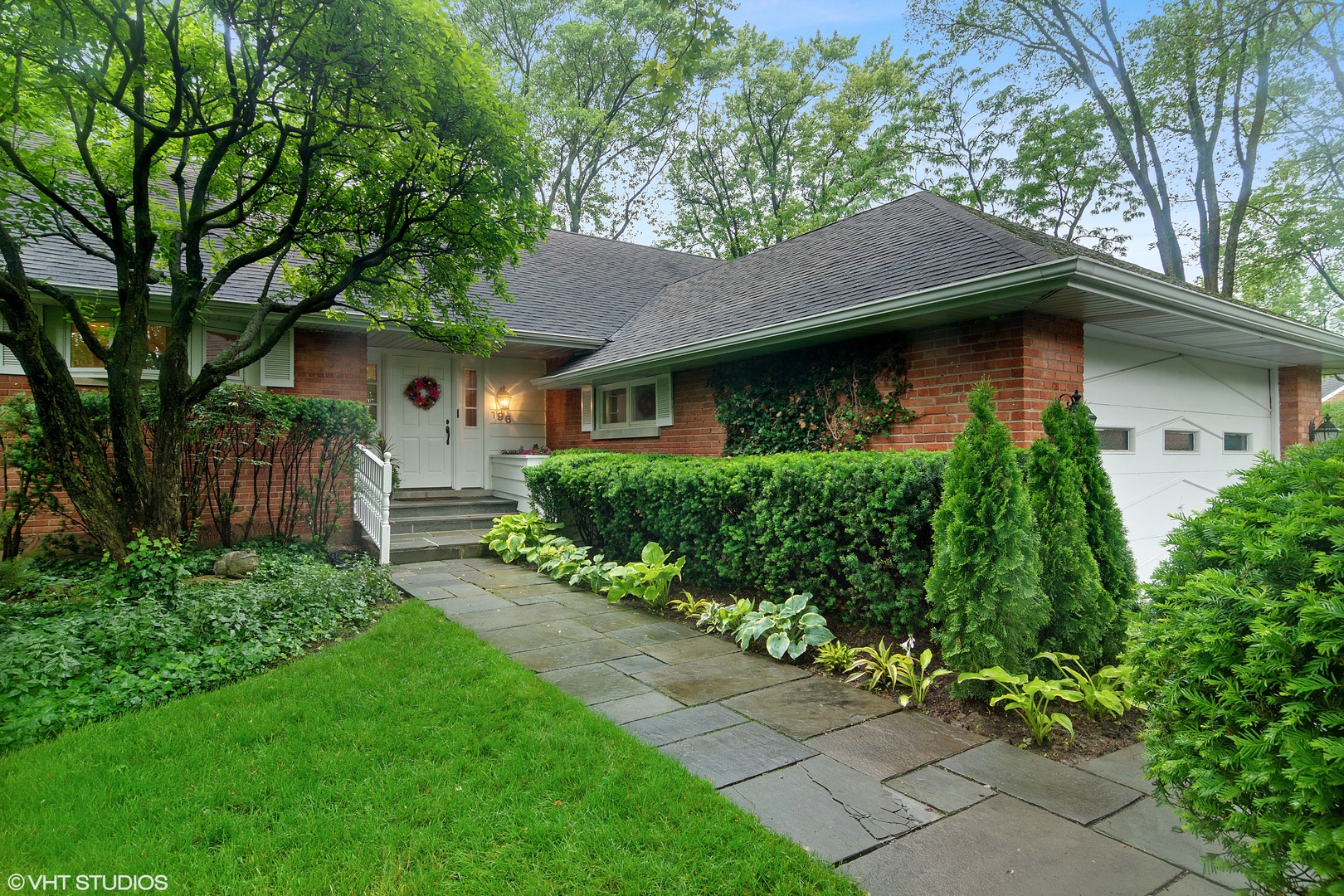 196 Coach Road Northfield, IL 60093 - Photo 1 of 36 a front view of a house with a garden