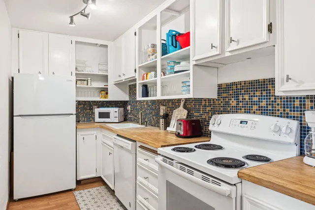 a kitchen with a white cabinets and white appliances