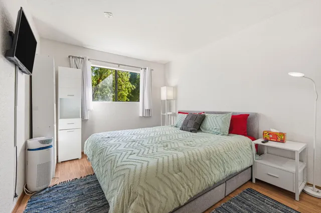 a bedroom with a bed and a flat screen tv