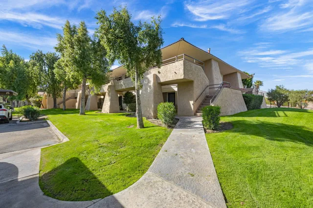 a front view of a house with yard and green space